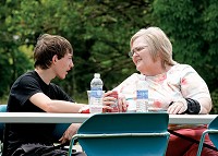 Nathaniel Clark, 14, Austin, and Edith Engbretson, 62, Austin, talk after eating at the barbecue at the Community Outreach Center on Saturday. Locals had hamburgers, hot dogs and other sides available to them. Staff photo by Jerod Clapp