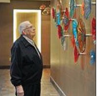 Wortman looks over the colorful plates located in the front area of the new cancer center. Each plate bears the name of someone who has donated to the cancer center. (Tom Russo | Daily Reporter)