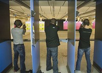 From left, Cory Riley of Goshen, Micah Hueni of Bremen and Gretchen Bellma of Bremen shoot pistols at Shoot to Thrill in Goshen on Jan. 9, 2016. (Sam Householder/The Elkhart Truth)