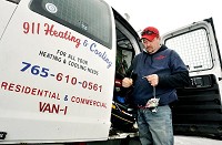 R.D. Poffenbarfer, owners of 911 Heating and Cooling in Anderson, strips some wiring as he prepares to install a part working on a job. He is boycotting Carrier Corp. products after they announced moving Huntington and Indianapolis plants with 1,400 jobs to Mexico. Staff photo by John P. Cleary