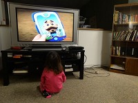A little girl watches television while staying at the Genesis shelter in Richmond. Staff file photo: Joshua Smith