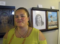 Tasia Stockstill, of LaPorte, who came up with the idea for a gallery of victims of heroin abuse, stands in front of portraits of a man and two women who died from heroin overdoses. Photo by Stan Maddux