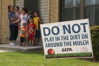 Marina Barajas stands with her children and sister, Tanya, Barajas, on Wednesday outside her home in East Chicago's West Calumet public housing complex. They've been told the soil around their homes is 'highly contaminated with lead and arsenic' and that it's in their best interests to temporarily relocate. Staff photo by John J. Watkins