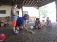 Lead teacher&nbsp;Jennifer Metzger teachers Manchester Early Learning Center students how to draw with sidewalk chalk on Wednesday. Staff photo by Eric Seaman