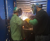 Cole Warner, (right) program coordinator for Vincennes University, shows Amber Gill how to weld at Lippert Components' Plant 19 in Goshen. Provided photo