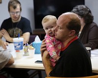 Biological father Jerry Stone-Hall of Washington holds baby Skyla during a parenting workshop he is attending with the mother of his children, Amber Stone-Hall, and her boyfriend, John O'Hara. Staff photo by Damian Rico