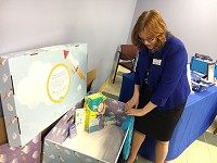 Renae Vania-Tomczak, president and CEO of Mental Health America of Lake County, shows of one of the infant sleep bundles that the organization will soon start giving to parents in Northwest Indiana. Staff photo by Giles Bruce