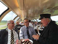 In this June 2016 photo, Eric Holcomb, left, then Indiana's lieutenant governor, Arvid Olson, head of Greater Lafayette Commerce's transportation committee, talk with a Hoosier State employee as they ride from Indianapolis to Lafayette on the Hoosier State train. This week, Gov. Eric Holcomb proposed a budget that would cut $3 million a year earmarked for the Hoosier State. Photo provided