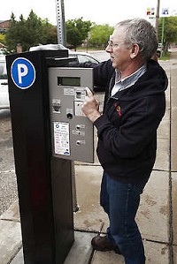 Roy Farris, an employee of EvensTime, installs a new parking pay station on Morton Street in May 2011. The pay stations replaced parking meters, accept credit cards or coins and operate in several languages. The use of similar stations is being proposed for much of downtown Bloomington's on-street parking. David Snodgress | Herald-Times
