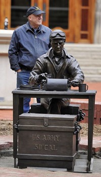 Tuck Langland, sculptor, stands behind his work during the installation of a bronze Ernie Pyle statue outside Franklin Hall at Indiana University in Bloomington, Thursday, Oct. 9, 2014.&nbsp;Chris Howell | Herald-Times