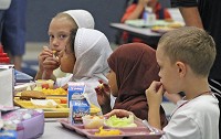 Topeka Elementary School students eat lunch in the cafeteria, Aug. 26, 2016. From left are Sara Slabach, Dunia alGurmi, Anisah Omar and Christopher Anderson. Staff photo by Roger W. Schneider