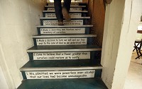 Therapist Matthew Lowery walks up the basement steps at the Moraine House in Valparaiso, the 12 Steps of Alcoholics Anonymous written on the steps. Staff photo by John Luke