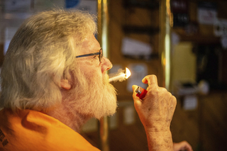 AN ADDICTION TO SMOKING:American Legion member Glen Spears smokes a cigarette inside the American Legion post in Fairmount. Staff photo by Clay Winowiecki