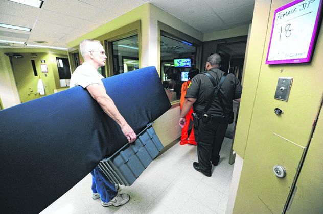 A jail trusty helps carry a bed for an incoming inmate at the Hancock County Jail. Staff photo by Tom Russo