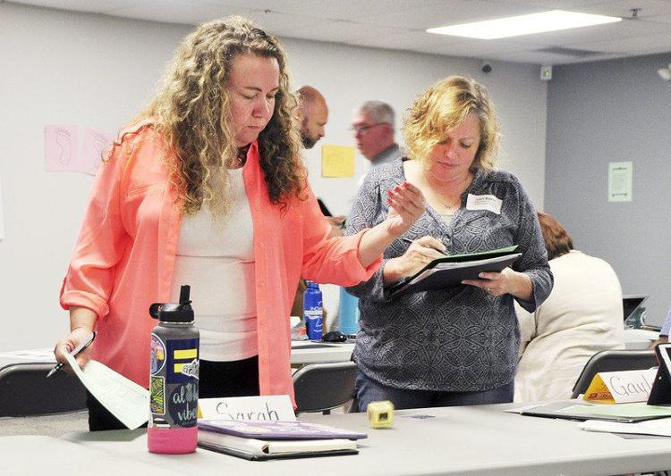 Participants at the Dynamics of Climate Workshop, hosted by Carmel Green Initiative, pretended to be carbon atoms and rolled dice to portray traveling in eras before and after the industrial revolution to understand how humans contribute to the carbon cycle. CNHI News Indiana photo by Scott L. Miley