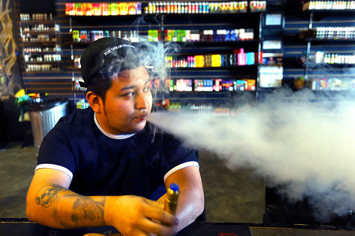 Memo Morales enjoys a flavored vape, which for him is an alternative to the two packs of cigarettes he used to smoke every day. Photo by Tim Bath | Kokomo Tribune