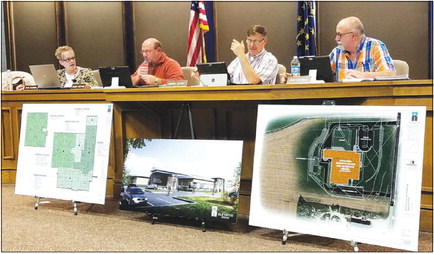 Fulton County Council members, from left, Phyl Olinger, Randy Sutton, Barry Hazel and Ron Dittman, discuss a proposed income tax increase before their Tuesday vote to approve. On the floor in front of them, a schematic drawing of the county’s proposed new jail, an architect’s rendering of the building’s exterior and, in orange, the property off Sweetgum Road the county has purchased for the planned building. 
The Sentinel photo / Wesley Dehne