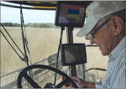 Good yield: Ervin Buse, who helps Terry Hayhurst harvest in the Fall, remarks on how well one field of soybeans grew while driving a combine on Friday afternoon at Hayhurst’s farm in southwest Vigo County.  Staff photo by Austen Leake