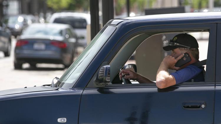 A man drives in downtown South Bend while using a cellphone. Staff photo by SANTIAGO FLORES/