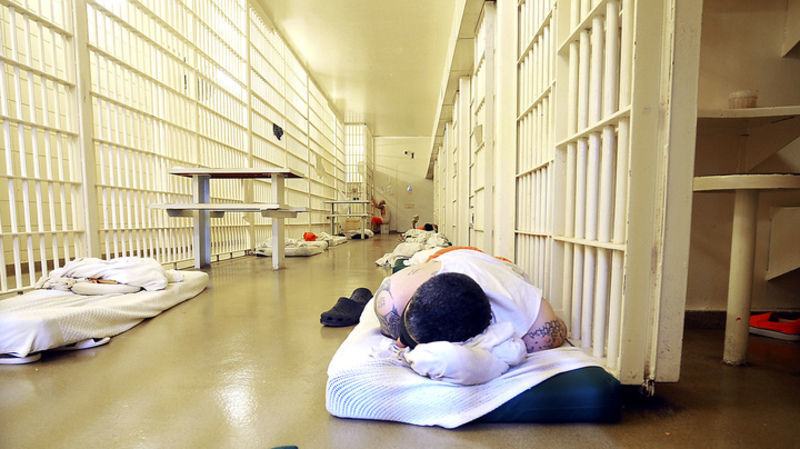 An offender sleeps in the hallway outside the cells in Cell Block “D” in the Vigo County Jail. The Terre Haute jail is under a court order to control its inmate population, and the county is building a new 496-bed, $56.1 million facility. CNHI News Indiana photo by JIm Avelis