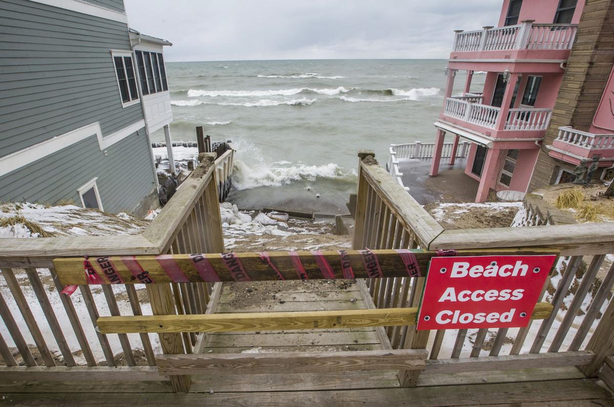 A closed beach sign is posted near the top of a washed out public access point near Lake Shore Drive along the southwest shoreline of Lake Michigan on Thursday in Long Beach. Staff photo by Robert Franklin