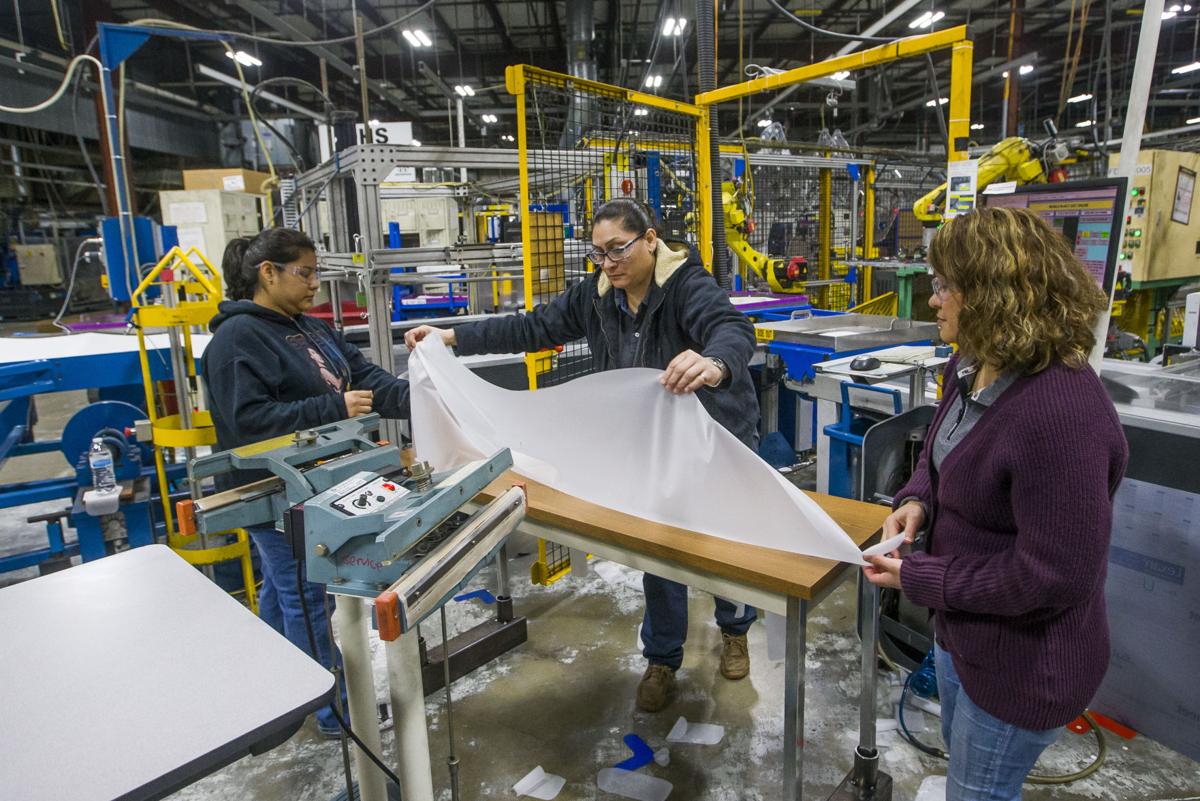 Workers at Nisco use machinery to make hospital gowns on Monday in Bremen. The company typically makes seals for the automotive industry. Staff photo by Robert Franklin