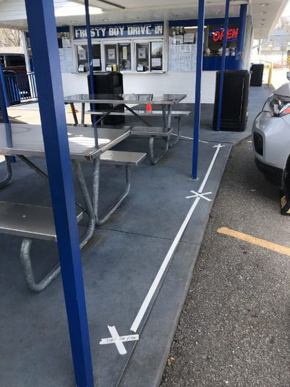 Masking tape marks the spots where people should stand wen ordering food at Frosty Boy in New Palestine. Staff photo by Kristy Deer