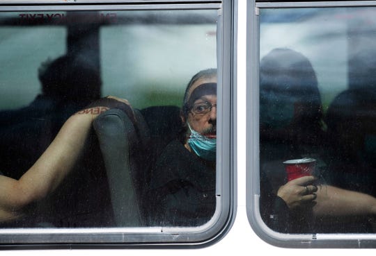 A resident of Washington Nursing Center at 603 E. National Hwy in Washington, Ind., watches the ruckus happening outside the bus he was riding in Monday afternoon, April 6, 2020. Protesters were blocking the bus from leaving the facility to transfer the residents to another Chosen Healthcare facility in Hanover, Ind. The company allegedly decided to turn the Washington, Ind., facility into a COVID-19 hospital. (Photo: DENNY SIMMONS / COURIER & PRESS)