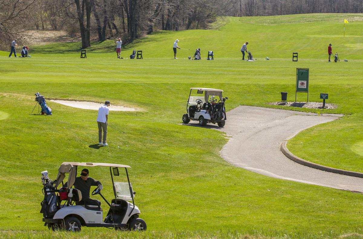 Golfers practice on the putting green and the driving range at Blackthorn Golf Club in South Bend Wednesday afternoon. Some local golf courses are keeping busy during the coronavirus pandemic. Staff photo by Robert Franklin