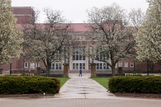 A lone pedestrian walks across the Memorial Mall at Purdue University, Friday, April 17, 2020 in West Lafayette. (Photo: Nikos Frazier | Journal & Courier)