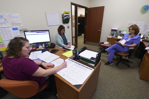 Brittany Cecil, left, Crystal Baker and Margie Hoskins compare notes on their contact tracing efforts. Staff photo by Tom Russo