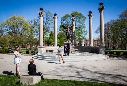 Students take graduation photos on a mostly empty Ball State campus Friday, May 1, 2020.  (Photo: Jordan Kartholl / The Star Press)