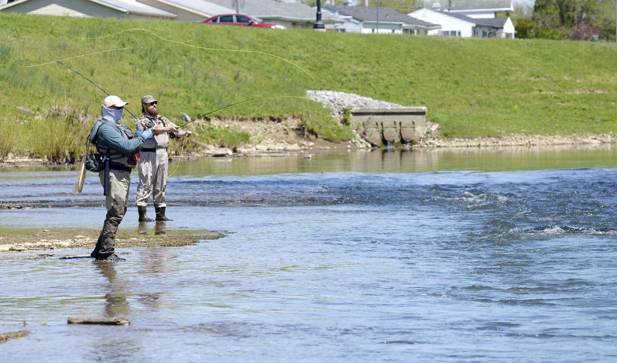 From left, Stephan Jones and Declan Craven fish in May along a section of the White River in Muncie, where two low-head dams were removed last year. “It has really added to the fishable water,” Jones said. Staff photo by Don Knight