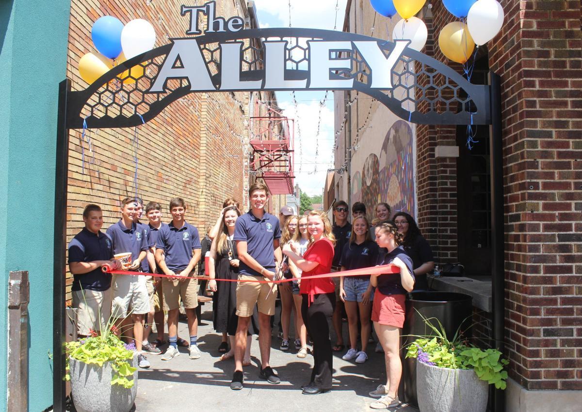 Kendallville Mayor's Youth Advisary Council members gathered Friday to dedicate The Alley, a downtown gathering place project funded and completed by the group. Holding scissors are current MYAC President Ben Jansen and former president Hailey Meyer. Staff photo by Steve Garbacz