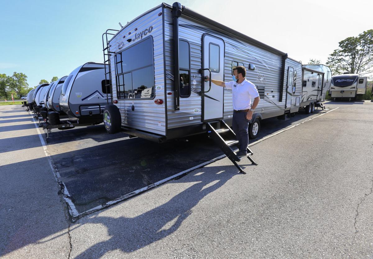 Camp-land RV spokesman Scott 'Otto' Ourednik opens one of the camping trailers on the lot at the dealership in Burns Harbor. Staff photo by John Luke