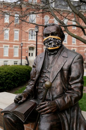 A statue of John Purdue, the founder of Purdue University, is seen wearing a Purdue surgical mask, Tuesday, April 7, 2020, in West Lafayette. Staff photo by Nikos Frazier