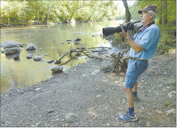 Jerry Byard checks the banks of the White River for water birds or sunning turtles while hiking the trail at Mounds State Park. A lifelong photographer, Byard started volunteering at the park when he retired. Staff photo by Don Knight