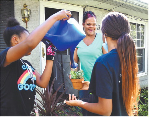 Brooke Watson has a laugh with her daughters, Heaven, 11, and Angel, 14, as they help water the plants at their Anderson home. The 39-year-old whose father is Black and whose mother is white, is among the 3.28% of Anderson residents who identified as more than one race on the 2010 census — much higher than state and national averages. Staff photo by John P.  Cleary