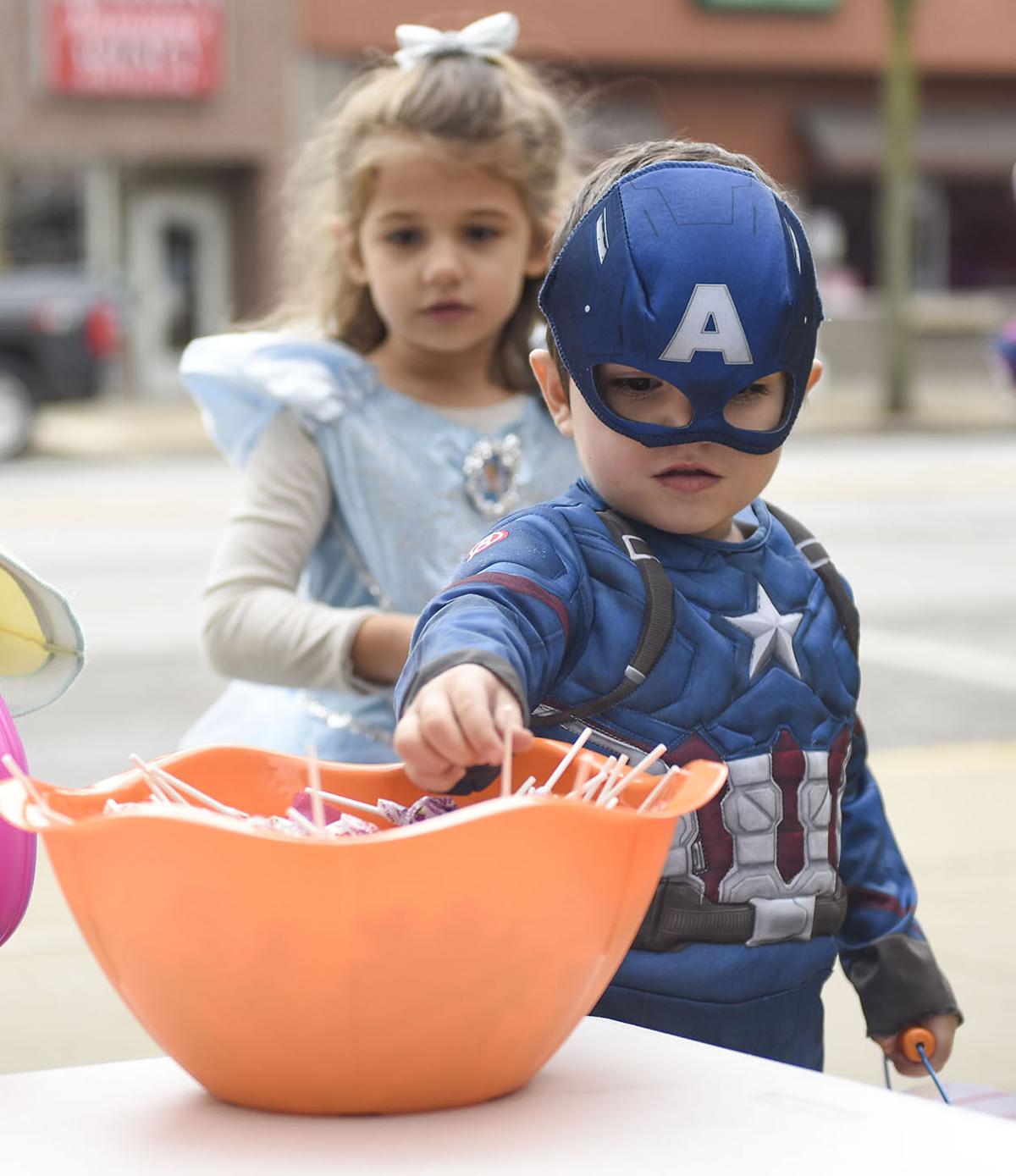 In this Oct. 18, 2018 file photo, Bronson Hurst, 3, dressed as Captain America, picks out candy with LeAnna Tayor, 5, both of Millersburg, while trick-or-treating in downtown Goshen. Stsff photo by Ben MIkesell