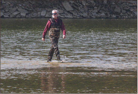 Highs and lows: Brendan Kearns walks across a portion of the Wabash River that is almost completely without water. However, several spots across the river are still deep and the current is strong enough to knock anyone over. Tribune-Star/Austen Leake