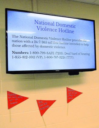 Information about domestic violence is shared on a screen in the Brownstown Central High School cafeteria, and below it are some red flags of domestic violence. These are part of students' Lead4Change project in Robin Perry's business management class. Staff photo by Zach Spicer