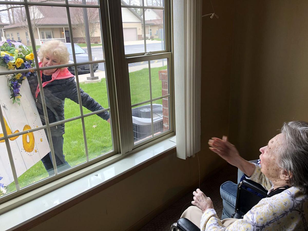 A family member visits with a resident through a window at a Kokomo senior care facility. Submitted photo