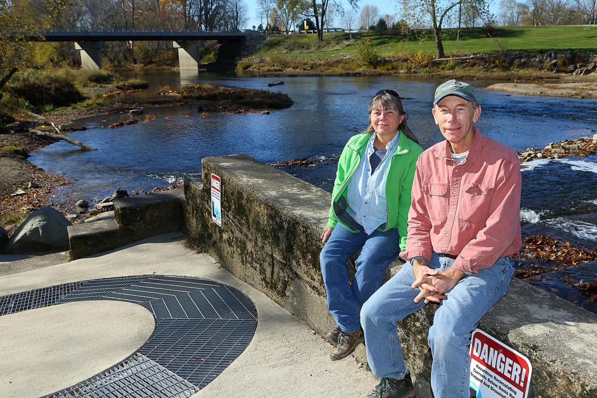 Melinda and Jerry Sweeten sit on top of the fish ladder on Tuesday, November 3, 2020, that was installed at Stockdale Mill along the Eel River in 2017. The device allows fish to swim up or down stream past the dam. Staff photo by Kelly Lafferty Gerber
