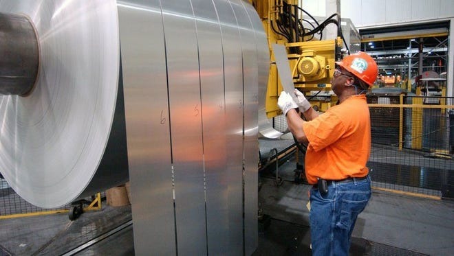 An employee is seen inspecting rolls of finished aluminum in the mill Alcoa Warrick Operations in April 2006. Staff file photo by Daniel R. Patmore