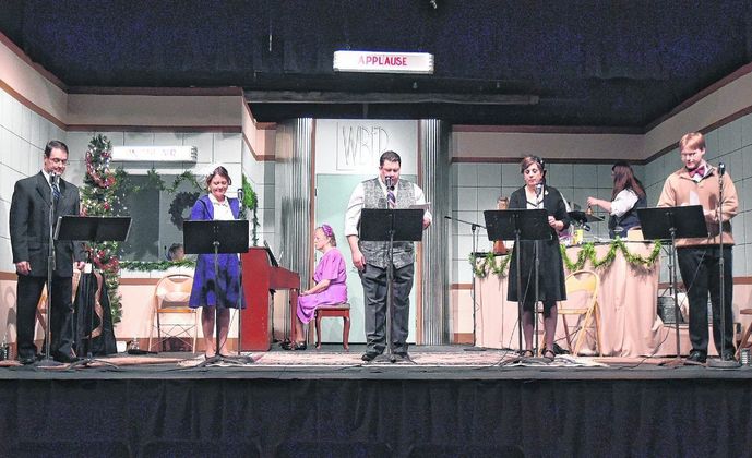Front from left, Greg Simons, MaryAnna Moore, John Boyken, Erin Moore and Evan Rohlfing rehearse for JCCT's production of "It's a Wonderful Life, A Live Radio Play" on Monday night. In the background from left are Stephanie Sunderman in the sound room, Connie Hardaway on piano and Mariah Dillon on sound effects. Staff photo by Zach Spicer