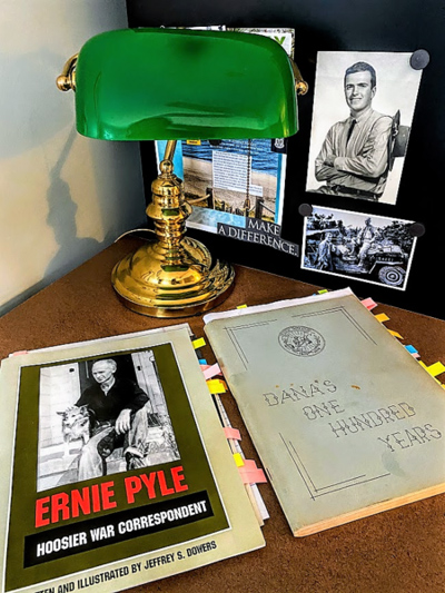 tPart of a heritage: On her desk at her Raleigh, N.C., home, Baptist minister and author Dana Trent keeps mementos of her youth in the Indiana town of Dana, for which she was named. The items include books about fellow Dana native Ernie Pyle and the town, and photos of Pyle and Trent’s father, the late Richard Lewman. Trent is assisting the effort to bring a community center to the town Photo courtesy J. Dana Trent