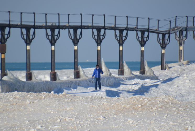 The shifting ice can be filled with cracks and holes, and is someone falls in, they would likely die, according to the Great Lakes Surf Rescue Project, which warns people to keep away from piers in the winter, unlike this visitor to Washington Park in Michigan City last week. Staff photo by Amanda Haverstick