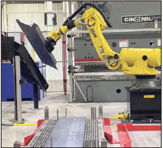 A helpful hand: A robotic arm lifts a heavy metal piece to bring over to a hydraulic press brake machine used to make an upper coupler part on Friday at Great Dane in Terre Haute. Staff photo by Howard Greninger