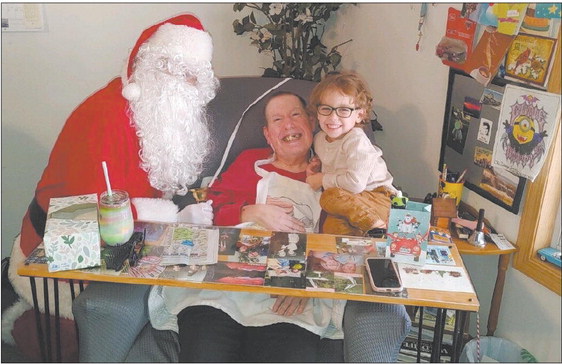 James “Dougie” Upchurch lives at Moses Caregiver Home in Valparaiso, which provides private care for Upchurch, who has cerebral palsy. Here, Upchurch poses with Santa and Xander, the son of a caregiver, at a Christmas celebration. Image provided by Liz Moses