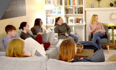 Current and former program participants at Place of Grace watch a program on the television at the organization’s recovery home in Huntington in February 2022. Staff photo by Brett Stover